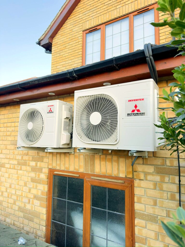 Two Mitsubishi outdoor units installed on a brick home – Airhive UK